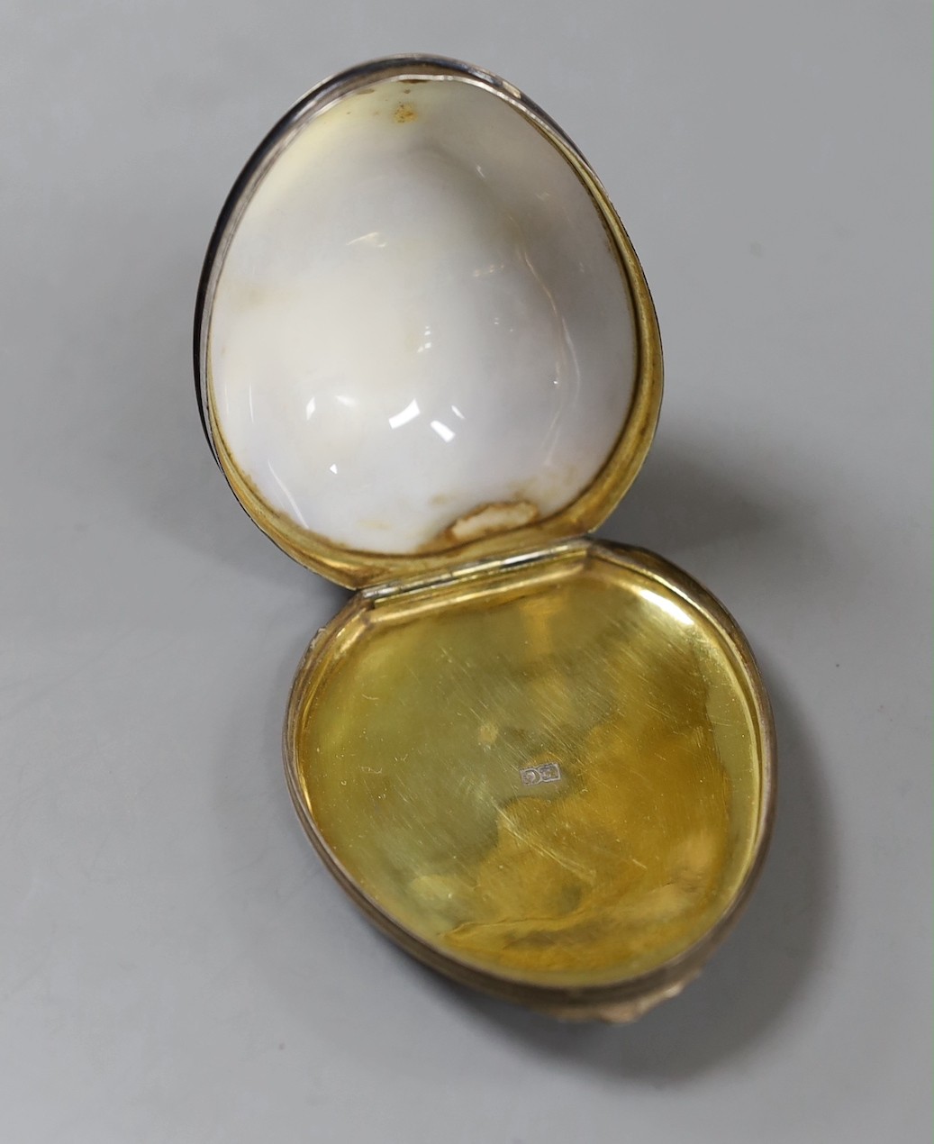 A late 18th/early 19th century white metal mounted cowrie shell snuff box, maker's mark only EC, 71mm.